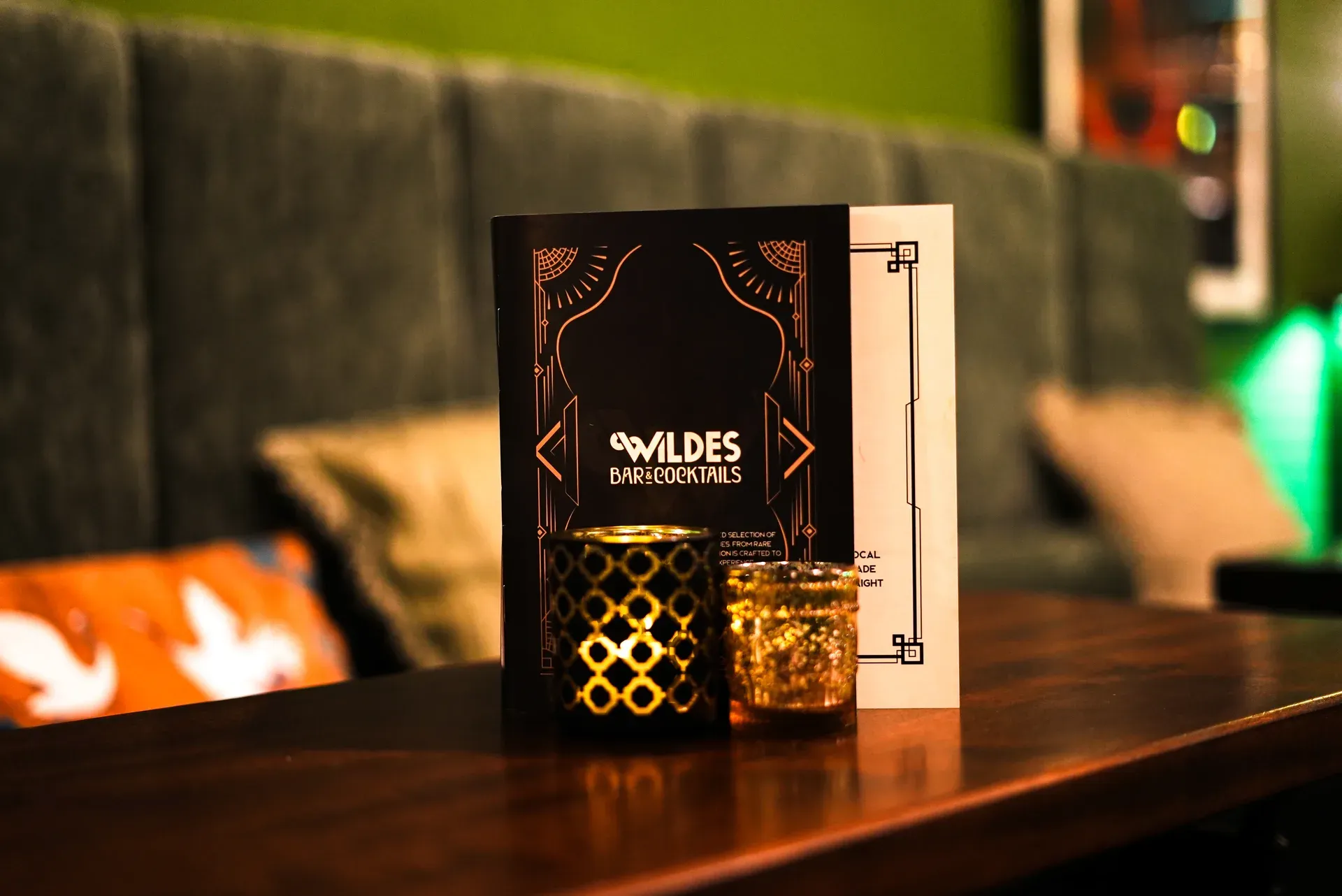 A candlelit table and menu inside Wildes wine and cocktail bar.